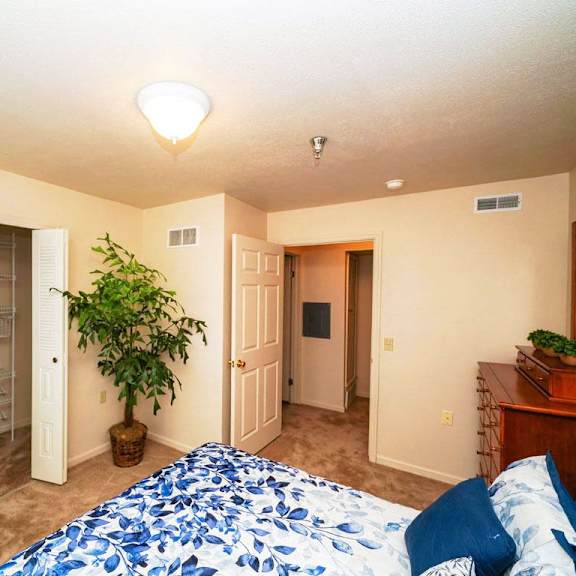 Thumbnail 8 of 8 a bedroom with a large bed and a closet at Gull Prairie/Gull Run Apartments and Townhomes, Michigan