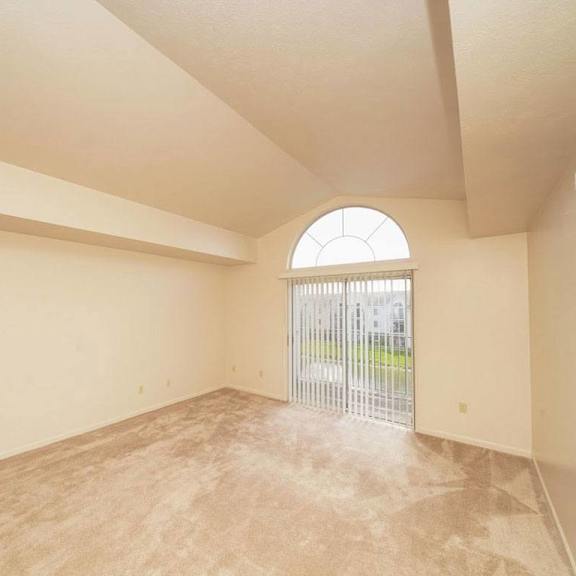 Thumbnail 4 of 6 an empty living room with a door to a patio at Gull Prairie/Gull Run Apartments and Townhomes, Kalamazoo, MI, 49048