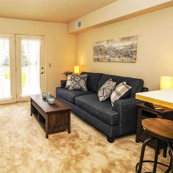 Thumbnail 3 of 6 a living room with a couch and a table at Gull Prairie/Gull Run Apartments and Townhomes, Michigan, 49048