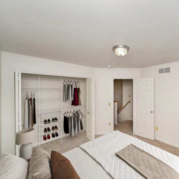 Thumbnail 8 of 9 A bedroom with a bed, and a walk-in closet with wardrobe organizers at Gull Prairie/Gull Run Apartments and Townhomes, Michigan, 49048