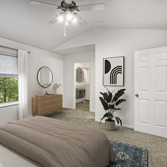 Thumbnail 7 of 9 A bedroom with a cathedral ceiling, ceiling fan, and a large bed at Gull Prairie/Gull Run Apartments and Townhomes, Michigan, 49048