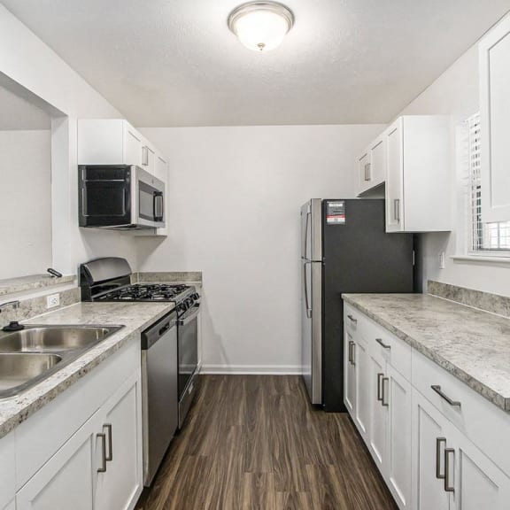 Thumbnail 8 of 28 a kitchen with stainless steel appliances and white cabinets at Gull Prairie/Gull Run Apartments and Townhomes, Kalamazoo, Michigan