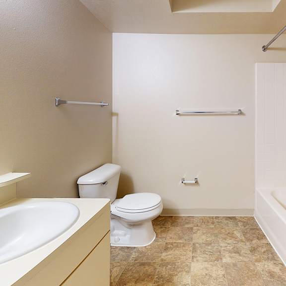 Thumbnail 7 of 12 A bathroom with a toilet, sink, and bathtub at Gull Prairie/Gull Run Apartments and Townhomes, Kalamazoo, MI, 49048