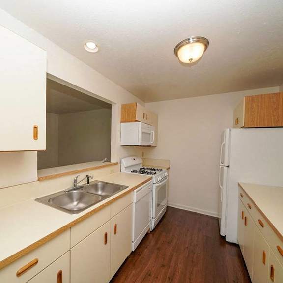 Thumbnail 6 of 14 a kitchen with a hard surface floor and a built in dishwasher and microwave at Gull Prairie/Gull Run Apartments and Townhomes, Kalamazoo, MI