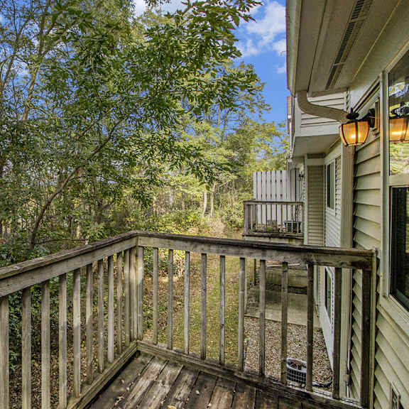 Thumbnail 4 of 15 A wooden deck overlooks a wooded area at Gull Prairie/Gull Run Apartments and Townhomes, Michigan, 49048