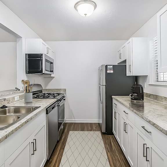 Thumbnail 6 of 15 A kitchen with white shaker-style cabinets and stainless steel appliances at Gull Prairie/Gull Run Apartments and Townhomes, Kalamazoo, MI