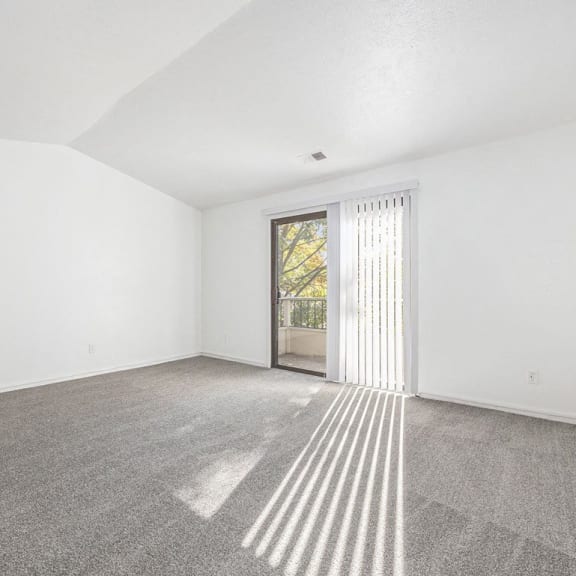 Thumbnail 7 of 14 living room with a sliding glass door to a balcony at Hampton Lakes Apartments, Michigan, 49534