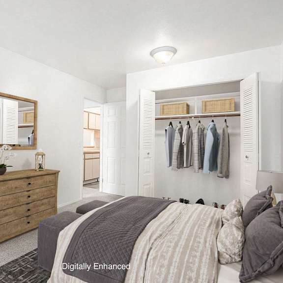 Thumbnail 14 of 15 A bedroom with a bed, dresser, and mirror with closet at Hampton Lakes Apartments, Michigan, 49534