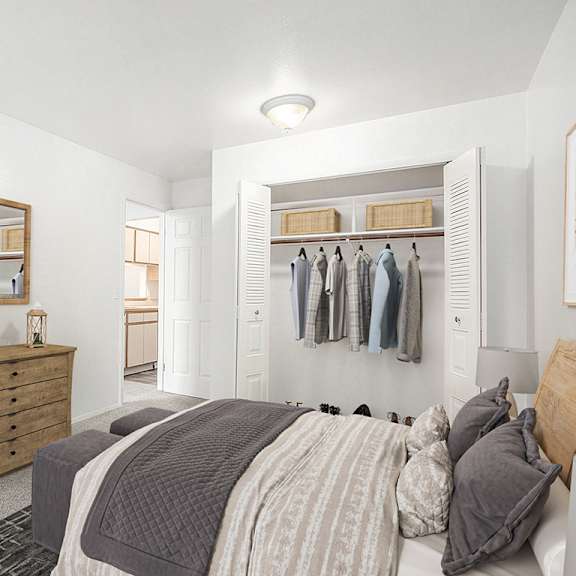 Thumbnail 13 of 14 A bedroom with a bed, dresser, and mirror with closet at Hampton Lakes Apartments, Michigan, 49534