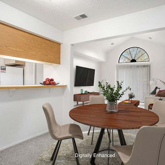 Thumbnail 3 of 15 A dining room leading to a living room with a cathedral ceiling at Hampton Lakes Apartments, Michigan, 49534