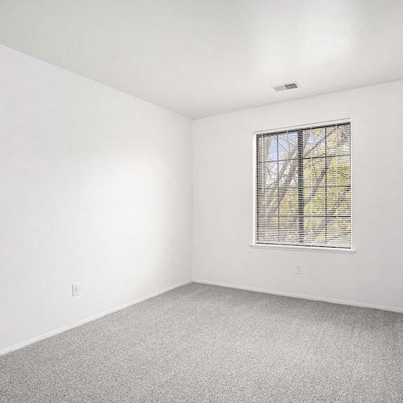 Thumbnail 13 of 15 an bedroom with a large window at Hampton Lakes Apartments, Michigan, 49534
