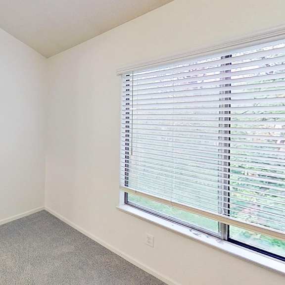 Thumbnail 12 of 18 A master bedroom with a window covered by white blinds and an ensuite bathroom at Foxwood and The Hermitage, Portage, 49024