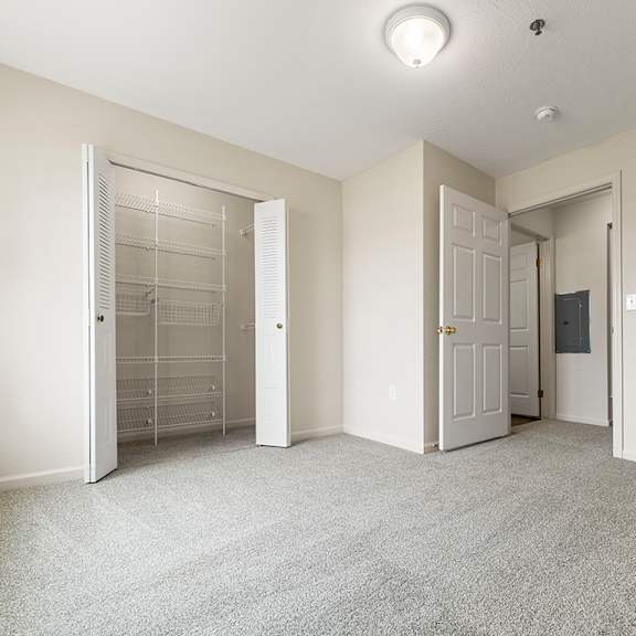 Thumbnail 12 of 12 A bedroom with a carpeted floor and a walk-in closet at Hunters Pond Apartment Homes, Champaign, IL