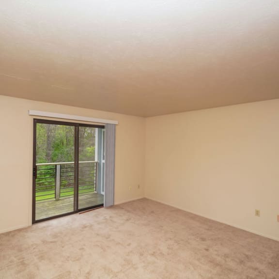 Thumbnail 6 of 17 an empty living room with a sliding glass door to a patio  at Hurwich Farms Apartments, South Bend