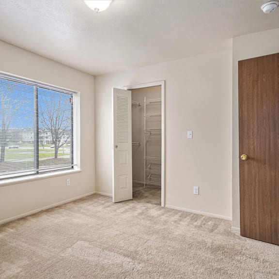 Thumbnail 11 of 12 bedroom with a large window and a door to a closet at Indian Lakes Apartments, Mishawaka, 46545