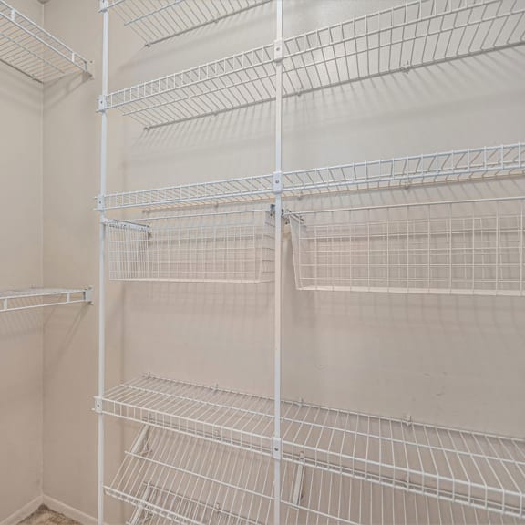 Thumbnail 12 of 12 the walk in closet in the master bedroom has white wire shelves at Indian Lakes Apartments, Mishawaka