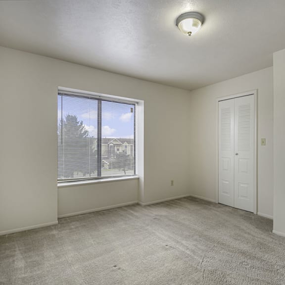 Thumbnail 10 of 13 bedroom with a large window and a door to a closet at Indian Lakes Apartments, Mishawaka