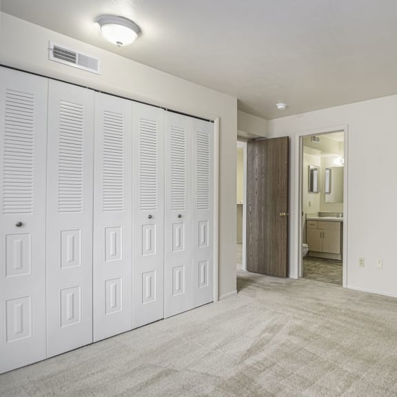 Thumbnail 12 of 13 an empty bedroom with white closets and a carpeted floor at Indian Lakes Apartments, Indiana