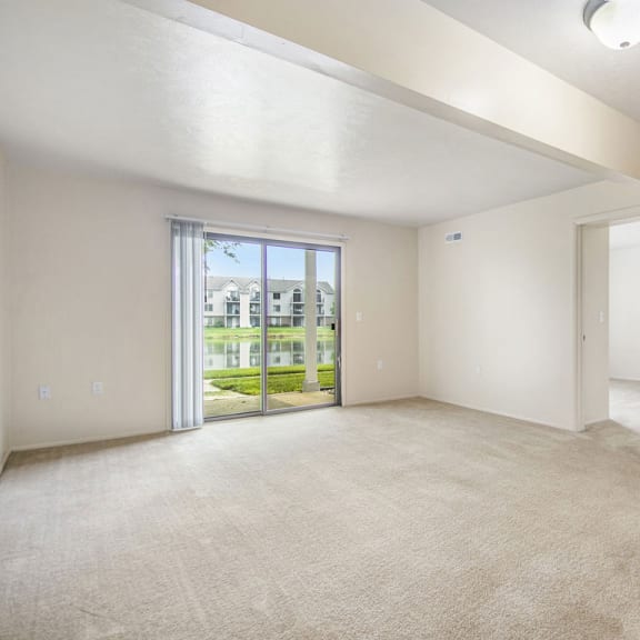 Thumbnail 6 of 13 an empty living room with a door to the patio  at Indian Lakes Apartments, Mishawaka, 46545