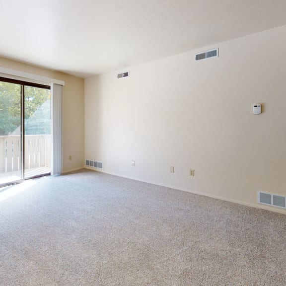 Thumbnail 5 of 14 an empty living room with a sliding glass door to a balcony at Irish Hills Apartments, South Bend, 46614