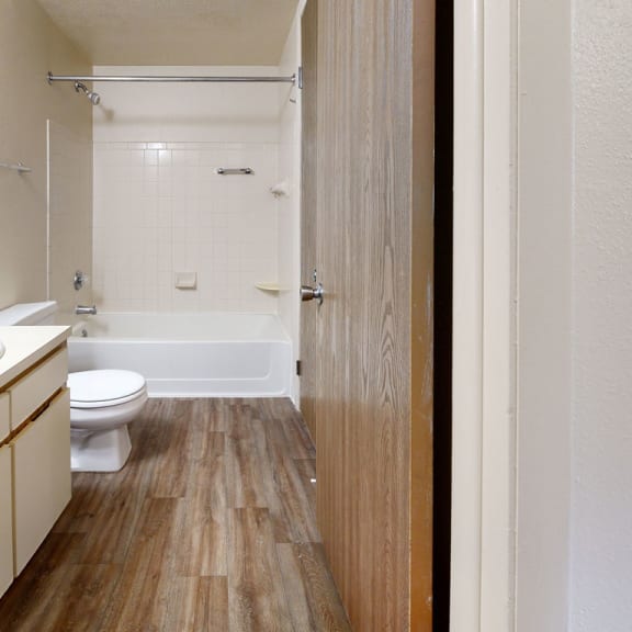 Thumbnail 4 of 7 an empty bathroom with a toilet and a tub at Irish Hills Apartments, Indiana