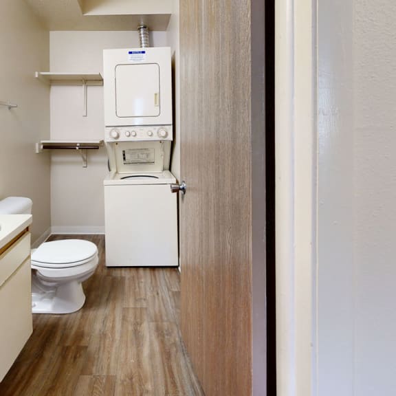 Thumbnail 6 of 7 a bathroom with a toilet and a washing machine in it at Irish Hills Apartments, South Bend, Indiana