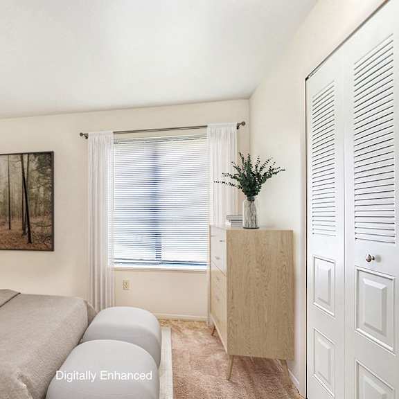 Thumbnail 11 of 14 A bedroom with a bed, a nightstand, a cabinet, and a closet at Irish Hills Apartments, South Bend, Indiana