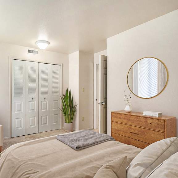 Thumbnail 12 of 13 A bedroom with a bed, chair, a large window and a closet at Irish Hills Apartments, South Bend, Indiana