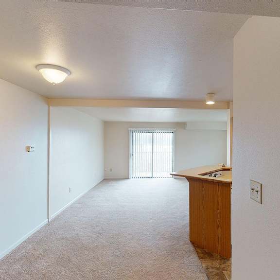Thumbnail 3 of 8 A dining and living room with sliding glass doors to a balcony at Liberty Mills Apartments, Fort Wayne