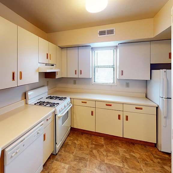 Thumbnail 6 of 8 A kitchen with white appliances and wooden cabinets at Liberty Mills Apartments, Fort Wayne