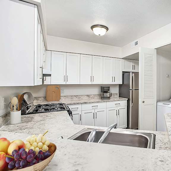 Thumbnail 6 of 11 A kitchen with a marble counter top and white cabinets