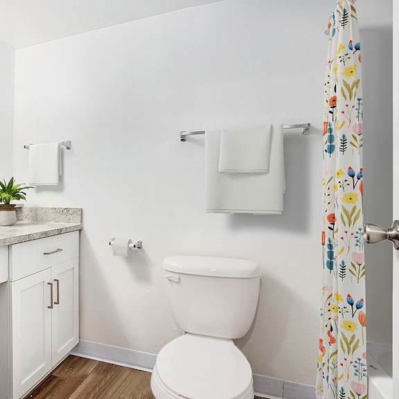Thumbnail 8 of 11 A white toilet sits next to a sink in a bathroom