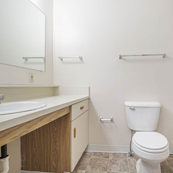 Thumbnail 9 of 10 A white toilet sits in a bathroom next to a sink and a bathtub at Liberty Mills Apartments, Fort Wayne