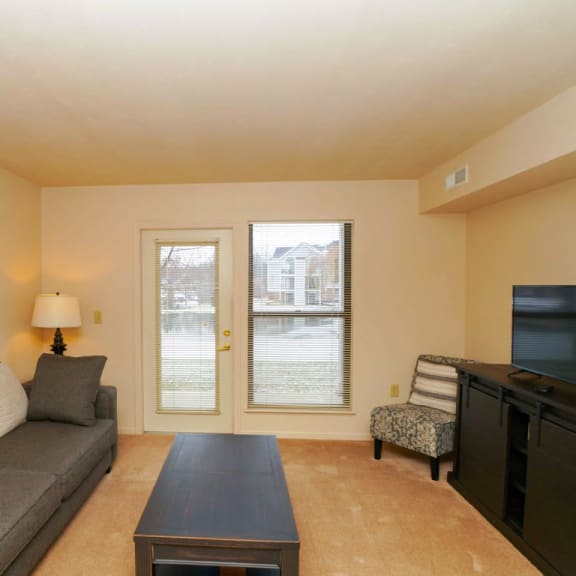 Thumbnail 4 of 10 first floor living room leading to a private patio at Liberty Mills Apartments, Fort Wayne