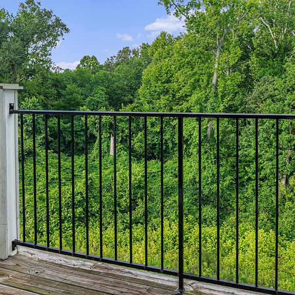 Thumbnail 4 of 21 A balcony with a black railing and a wooded view at Limestone Creek Apartment Homes, Madison, AL