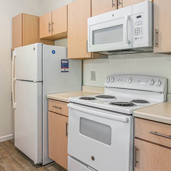 Thumbnail 9 of 21 A kitchen with a white refrigerator, stove, and microwave at Limestone Creek Apartment Homes, Madison, AL