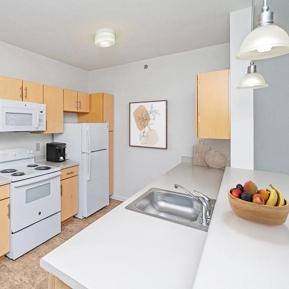 Thumbnail 10 of 21 a kitchen with white appliances and wooden cabinets at Limestone Creek Apartment Homes, Madison, AL