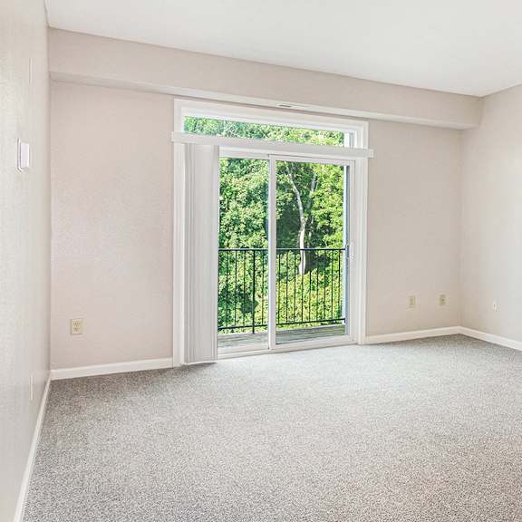 Thumbnail 3 of 21 A living room with a 9 foot ceiling and a sliding glass door leading to a balcony at Limestone Creek Apartment Homes, Madison, AL