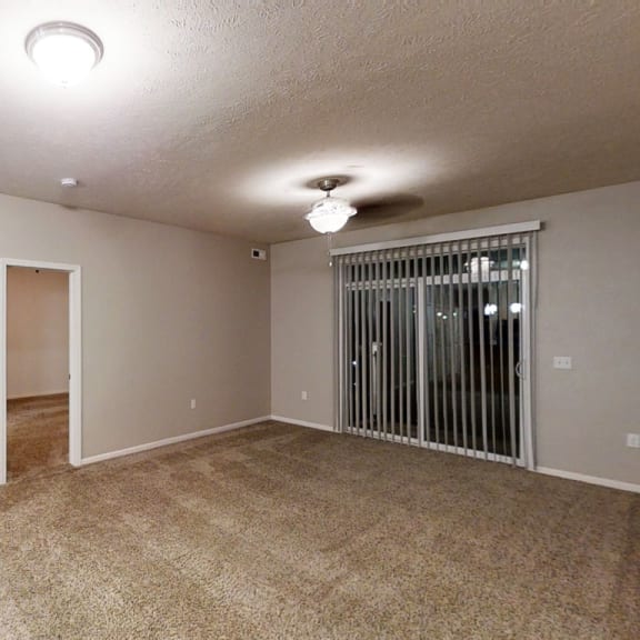 Thumbnail 4 of 12 an empty living room with a door to a closet  at Lynbrook Apartment Homes and Townhomes, Elkhorn, NE, 68022