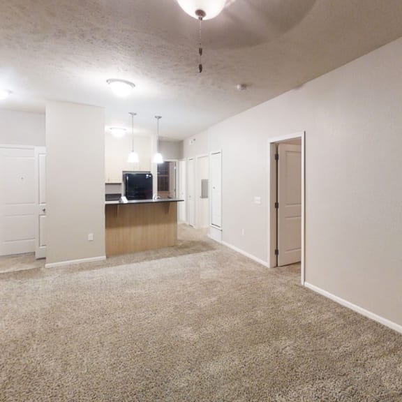 Thumbnail 5 of 12 an empty living room and kitchen with a carpeted floor  at Lynbrook Apartment Homes and Townhomes, Elkhorn, NE, 68022