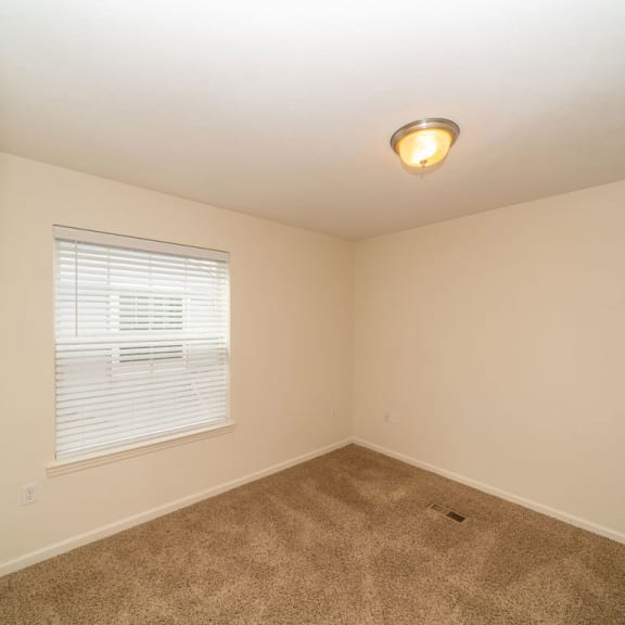 Thumbnail 10 of 15 A bedroom with a large window at Lynbrook Apartments and Townhomes, Elkhorn