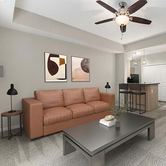 Thumbnail 5 of 12 A living room with a brown couch, a grey coffee table, and a ceiling fan at Lynbrook Apartments and Townhomes, Elkhorn, NE, 68022
