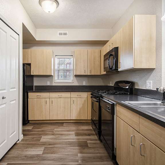 Thumbnail 7 of 15 A kitchen with a window and hard surface flooring at Lynbrook Apartments and Townhomes, Elkhorn, NE, 68022