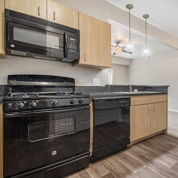 Thumbnail 8 of 15 A kitchen with black appliances and wooden cabinets at Lynbrook Apartments and Townhomes, Elkhorn, NE, 68022