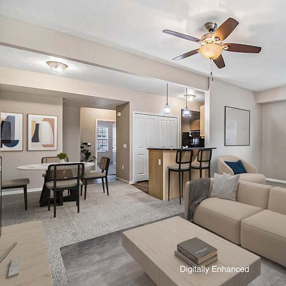 Thumbnail 4 of 15 A living room with a beige couch and a ceiling fan at Lynbrook Apartments and Townhomes, Elkhorn, NE, 68022
