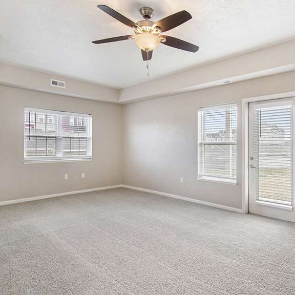 Thumbnail 9 of 15 An end style living room with a ceiling fan and carpeted floor at Lynbrook Apartments and Townhomes, Elkhorn, NE, 68022