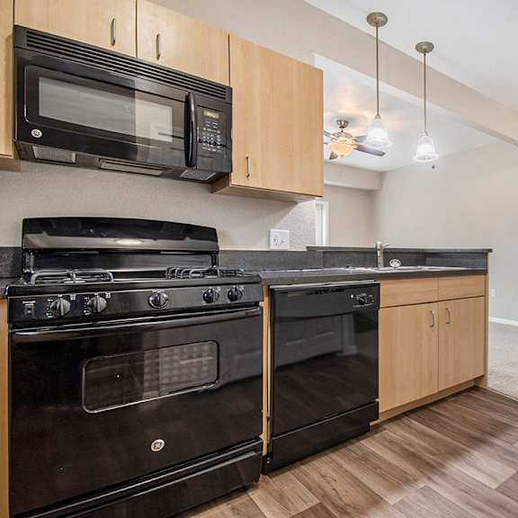 Thumbnail 6 of 12 A kitchen with black appliances and wooden cabinets at Lynbrook Apartments and Townhomes, Elkhorn, NE, 68022