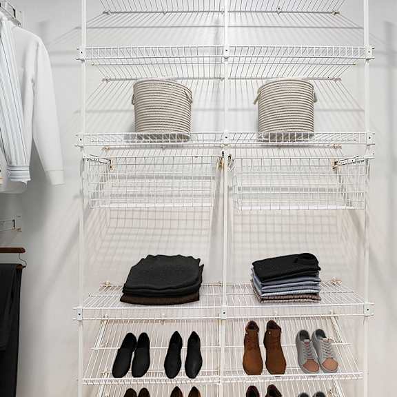Thumbnail 12 of 12 A walk-in closet with clothes and shoes organized on shelves at Lynbrook Apartments and Townhomes, Elkhorn, NE, 68022