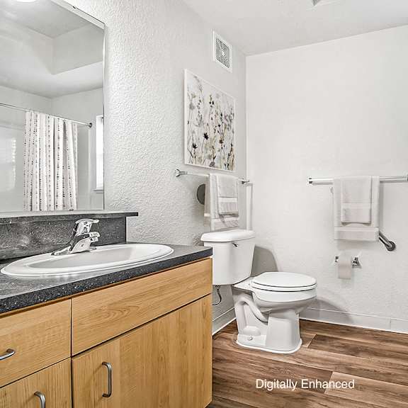 Thumbnail 12 of 15 A bathroom with a toilet, sink, and a window at Lynbrook Apartments and Townhomes, Elkhorn, NE, 68022