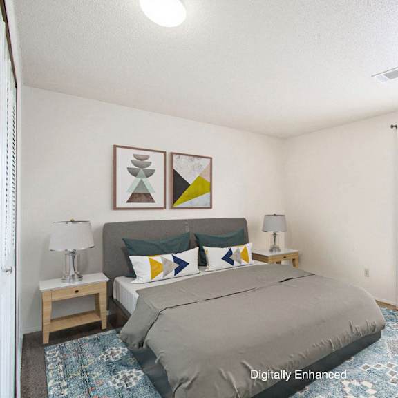 Thumbnail 8 of 9 A bedroom with a bed, chair, and a window at Madeira Apartments in Kalamazoo, MI 49001
